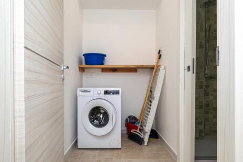a laundry room with a washing machine and a shelf at Case Vacanze Il Marchetto in Ottava Sassari