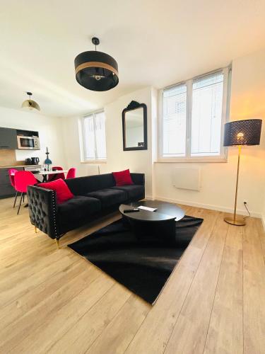 un salon avec un canapé noir et une table dans l'établissement Le Balnéo - Espace détente centre ville, à Quimper