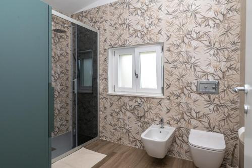 a bathroom with a sink and a toilet and a mirror at Case Vacanze Il Marchetto in Ottava Sassari