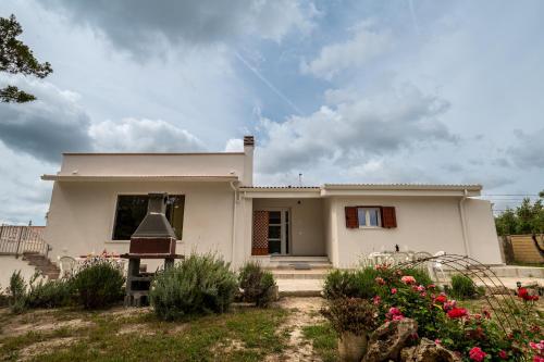 a white house with flowers in front of it at Case Vacanze Il Marchetto in Ottava Sassari