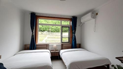 Postel nebo postele na pokoji v ubytování Gubeikou Great Wall Juxian Residents' Lodging