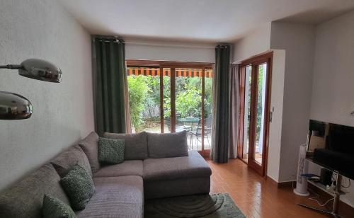 un salon avec un canapé et des portes coulissantes en verre dans l'établissement La plage et les commerces accessibles à pied, à Cannes