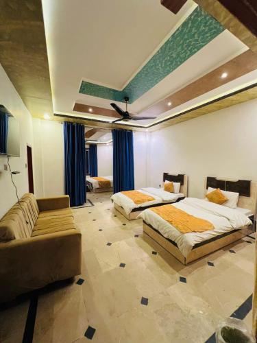 a bedroom with two beds and a couch at Hotel Malamjabba Palace by Khan Familia Travels in Swat