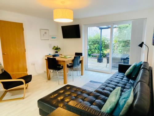 a living room with a couch and a table at Above the Bay - Enclosed garden apartment with parking in Penzance
