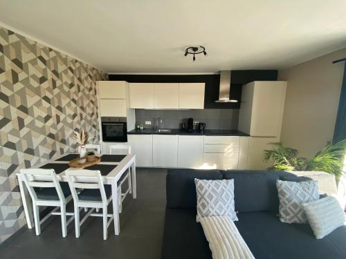 a living room with a blue couch and a kitchen at Le Coin de nature in Corenne