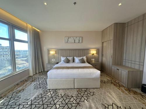 a bedroom with a large bed and a large window at Grand Line Hotel in Tabuk