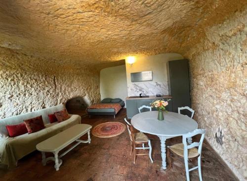 un salon avec un canapé et une table dans l'établissement La petite Troglo, à Aubigné-Racan