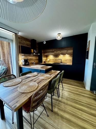 une cuisine avec une grande table et des chaises en bois dans l'établissement Appartement entre forêt, lac et océan, à Vieux-Boucau-les-Bains