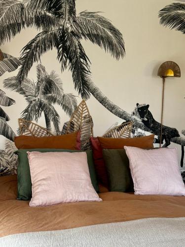 - une chambre avec un lit recouvert de palmiers dans l'établissement Appartement entre forêt, lac et océan, à Vieux-Boucau-les-Bains