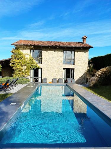 a villa with a swimming pool in front of a house at Relais la Corte di Lequio in Lequio Berria