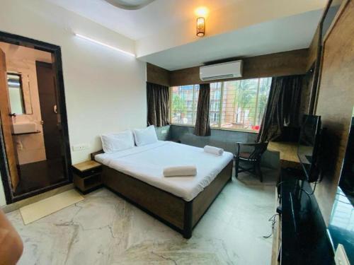 a bedroom with a bed and a television in it at Calangute Beach Way in Calangute