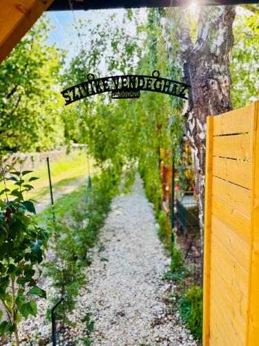 a garden path with a sign on a fence at Szivike Vendégház in Ábrahámhegy
