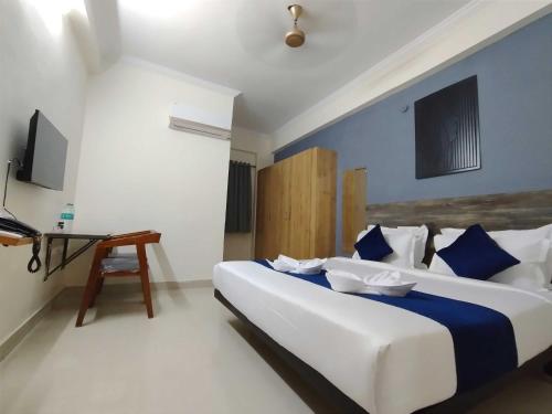 a bedroom with a large bed and a desk at Super Collection O Rio Kondapur Near Rahavendra Colony in Hyderabad