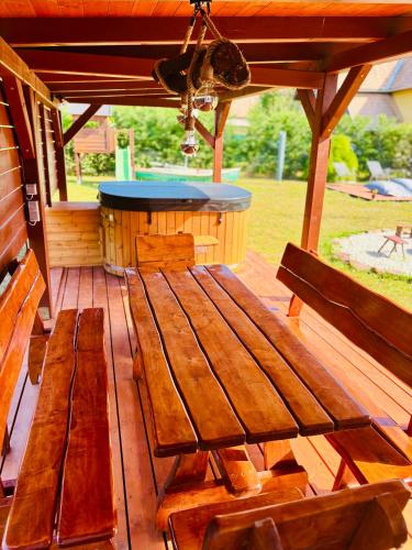 a wooden bench sitting on a deck with a bar at Szivike Vendégház in Ábrahámhegy
