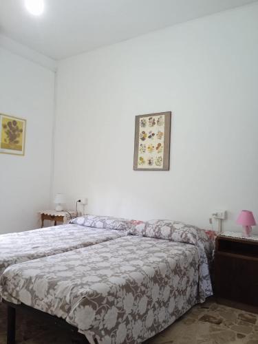 a bedroom with a bed and a white wall at Appartamento Il Salice in Carignano