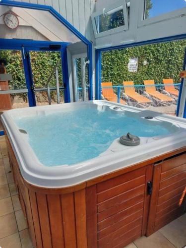 - un grand bain à remous dans une pièce avec des chaises dans l'établissement Le Bel Air, à Cancale