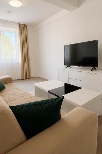 a living room with a couch and a flat screen tv at Harmony residence Ilidza in Sarajevo