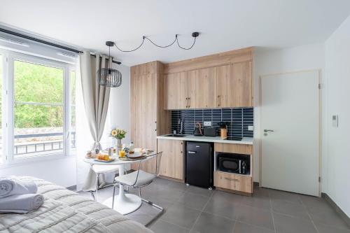 - une cuisine avec un lit et une table dans une chambre dans l'établissement Chic Studio Disneyland Paris, à Montévrain