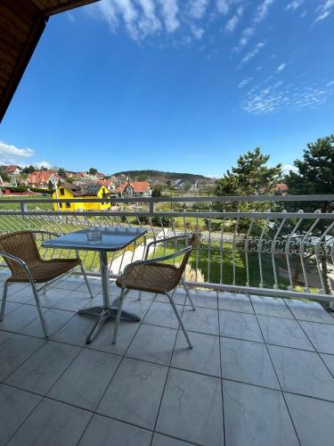 a patio with a table and chairs on a balcony at Főnix Apartmanház in Vonyarcvashegy