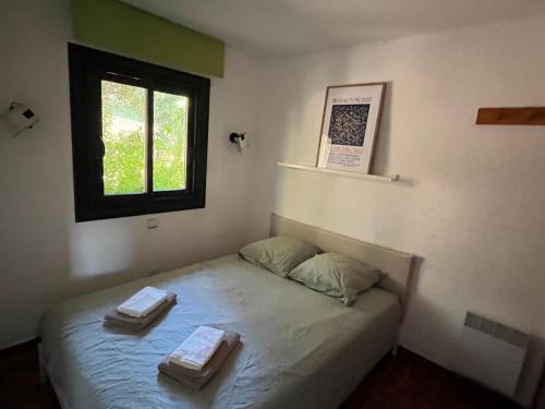 une chambre avec un lit avec deux serviettes dessus dans l'établissement Charmant 2 pièces avec vue sur mer exceptionnelle à Porticcio, Corse du Sud, à Grosseto-Prugna