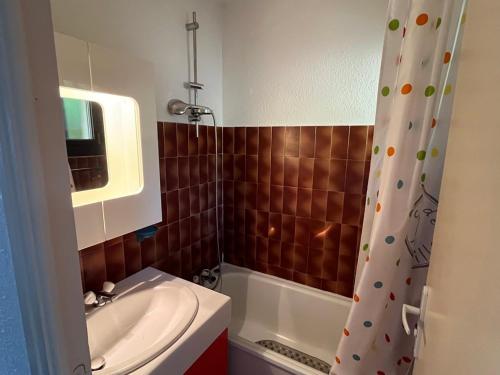 une salle de bain avec un lavabo et un rideau de douche dans l'établissement Charmant 2 pièces avec vue sur mer exceptionnelle à Porticcio, Corse du Sud, à Grosseto-Prugna