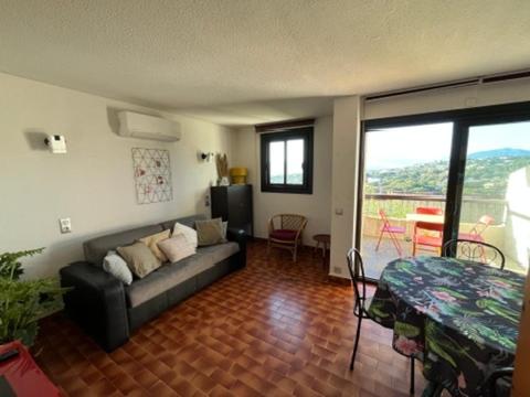 un salon avec un canapé et une table dans l'établissement Charmant 2 pièces avec vue sur mer exceptionnelle à Porticcio, Corse du Sud, à Grosseto-Prugna