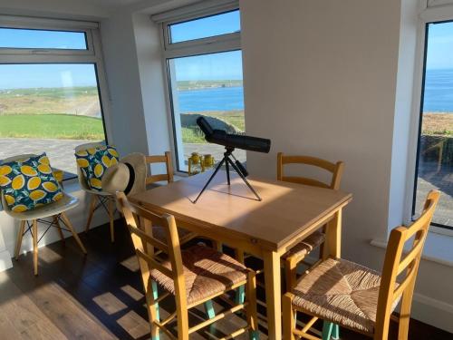 a dining room table with chairs and a camera on a tripod at West Cork holiday home with incredible sea views in Donoure