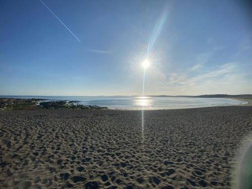 a beach with a light pole on the sand at West Cork holiday home with incredible sea views in Donoure