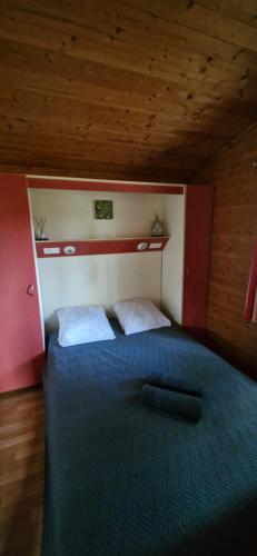 une chambre avec un lit avec une couette bleue dans l'établissement Chalet confort et détente, à La Celle-sous-Gouzon