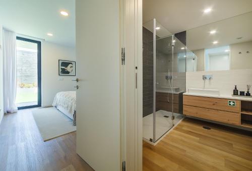 a bathroom with a shower and a sink and a bed at Art Living Gravito incl Parking by Home Sweet Home Aveiro in Aveiro