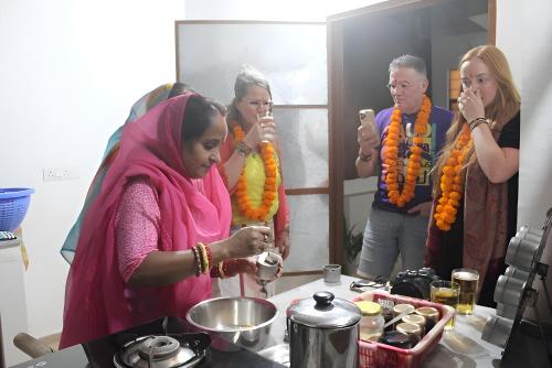 a group of people standing in a kitchen preparing food at Umaid Niwas Homestay in Jaipur