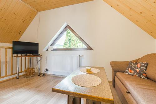 a living room with a couch and a table at Dulówka in Smerek