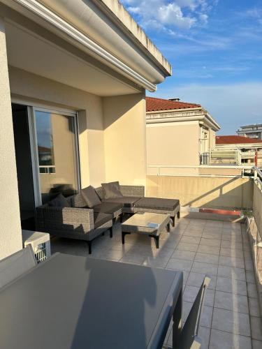 d'une terrasse avec des canapés et des tables sur un balcon. dans l'établissement T2 dans résidence standing Juan Flore dernier étage avec terrasse vue mer, à Antibes