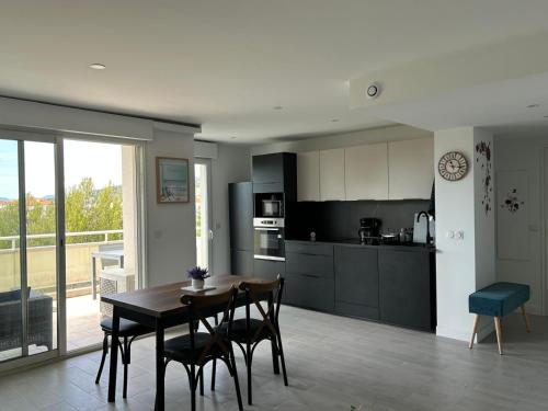 une cuisine et une salle à manger avec une table et des chaises dans l'établissement T2 dans résidence standing Juan Flore dernier étage avec terrasse vue mer, à Antibes