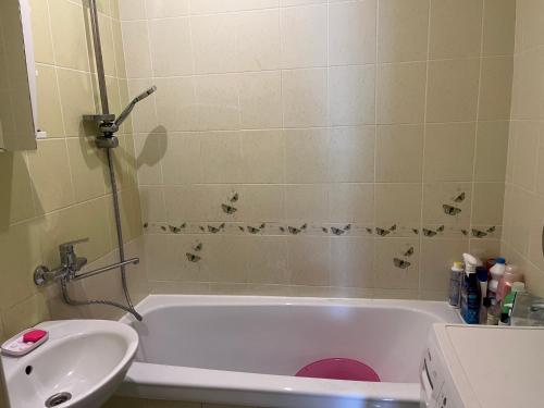 a bathroom with a white tub and a sink at Butas prie tvenkinio in Varėna