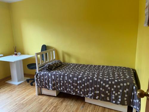 a bedroom with a bed and a desk and a table at Butas prie tvenkinio in Varėna