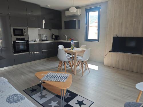 a kitchen and living room with a table and chairs at Central, brand new apart with parking in Blagoevgrad