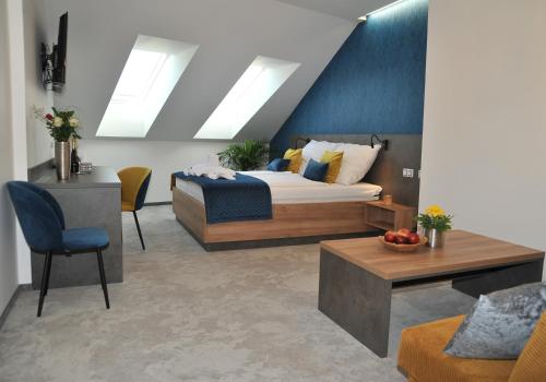 a bedroom with a bed and a table and chairs at HRADBY hotel a restaurace in Uničov