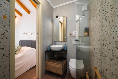 a bathroom with a sink and a toilet and a bed at Skriveni dragulj - A Peaceful Oasis with a Sea View in Trogir