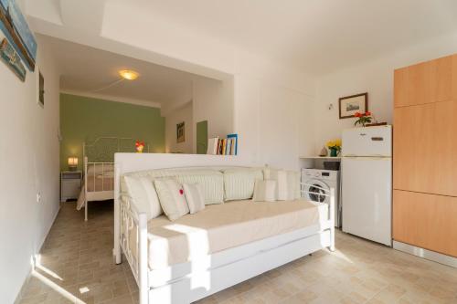 a living room with a white couch and a kitchen at Aloni Stone Studio with Private Parking in Lefkes