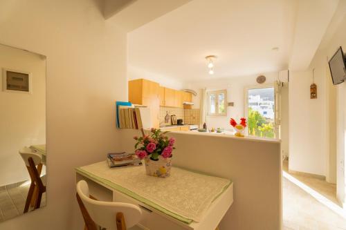 a kitchen with a table with a vase of flowers on it at Aloni Stone Studio with Private Parking in Lefkes