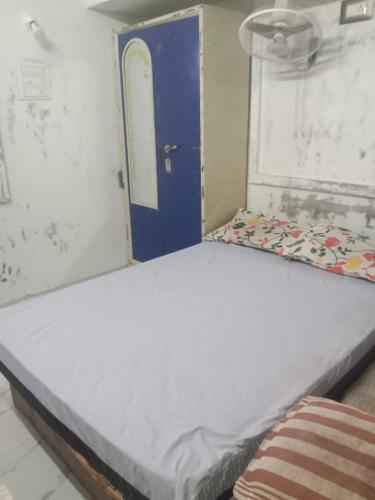 a large bed in a room with a blue door at TKM homestay in Tiruvannāmalai