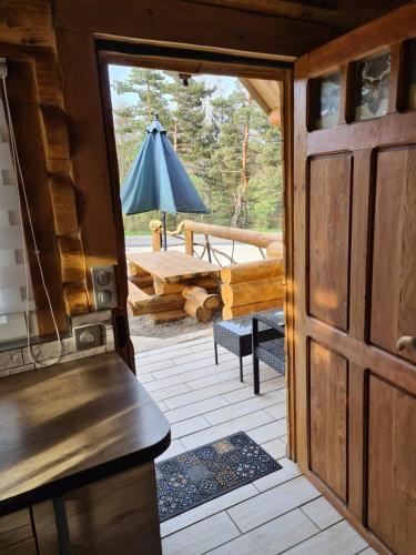 Une porte ouverte s'ouvre sur une terrasse avec une table. dans l'établissement Le chalet du Colibri, à La Celle-sous-Gouzon