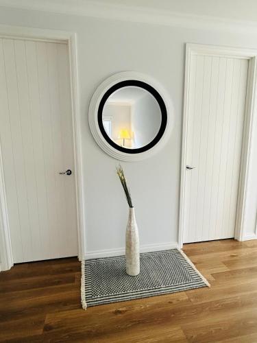 a room with a round mirror and a vase at Mt Atkinson Retreat in Truganina