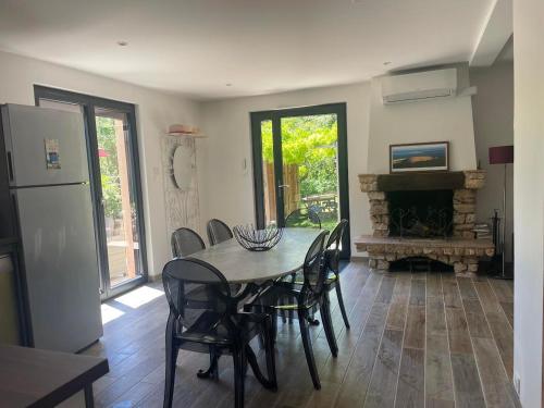 une salle à manger avec une table et des chaises et une cheminée dans l'établissement La Petite Maison des Baous, à Saint-Jeannet