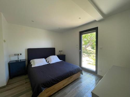 une chambre avec un lit et une grande fenêtre dans l'établissement La Petite Maison des Baous, à Saint-Jeannet