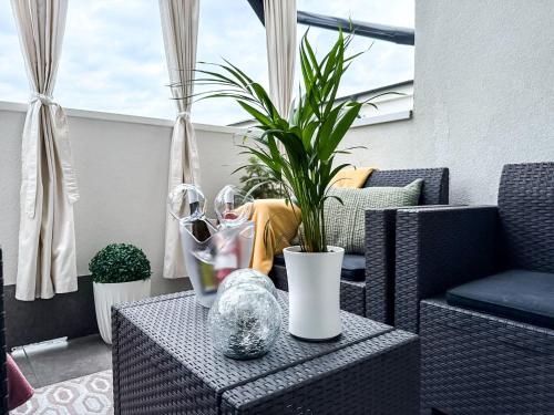 a table with a vase and a plant on it at White Home Luxury in Nyíregyháza