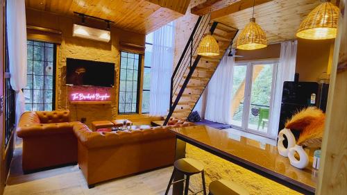 デヘラードゥーンにあるThe Brookside Bungalowのソファとテーブルのある広いリビングルーム