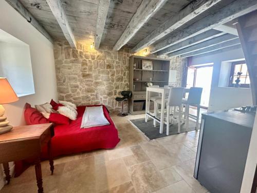 - un salon avec un lit rouge et une table dans l'établissement Maison de Saint Ours, à Moye