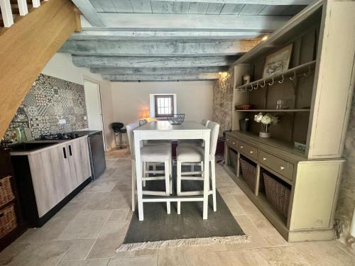 a kitchen with a counter and a table and a stool at Maison de Saint Ours in Moye